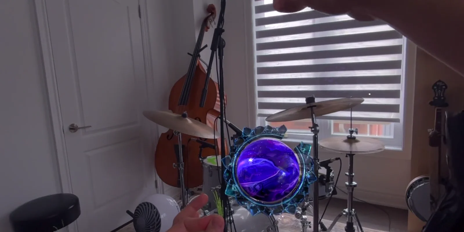 Zerno prototype: hands shaping a luminous crystal sphere in an augmented musical space